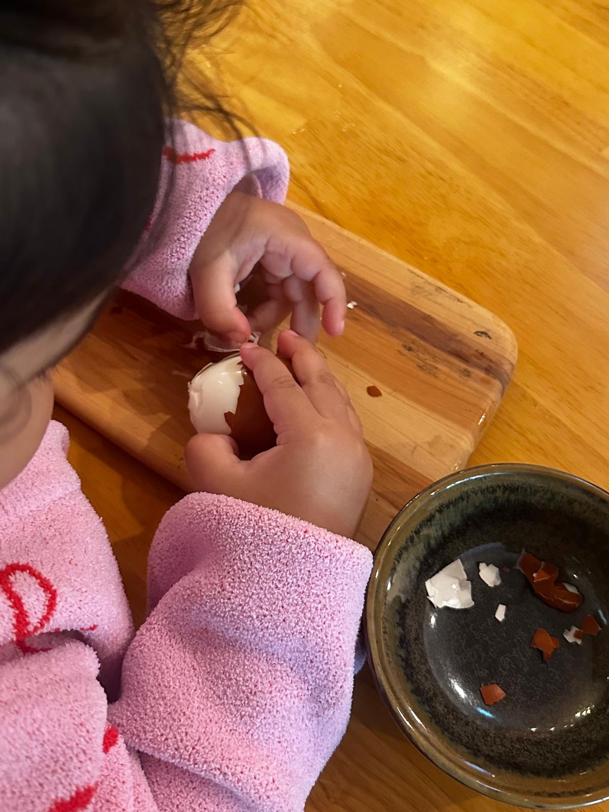 Child peeling a hard-boiled egg